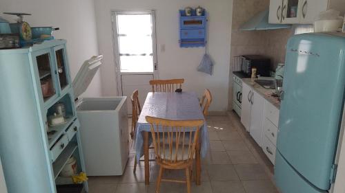 a kitchen with a table and chairs and a refrigerator at Complejo La Emilce in Olavarría