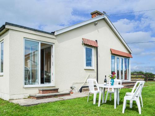 a table and chairs in front of a house at Sunny Bank - Uk34711 in Reighton