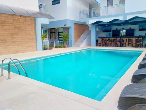 a swimming pool with blue water in a hotel at Havana Jaco in Jacó