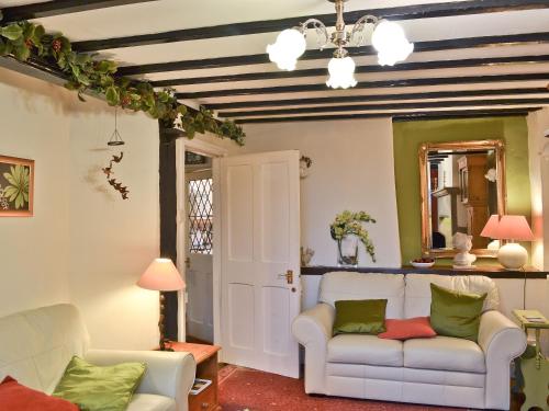 a living room with two white couches and a mirror at Tom's Cottage in Dalton in Furness