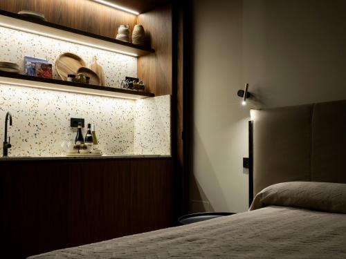 a bedroom with a bed and a shelf with plates at San Tommaso Suites & Spa in Bari