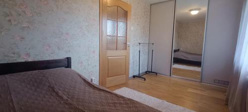 a bedroom with a bed and a door with a mirror at Apartments in the center of Narva in Narva