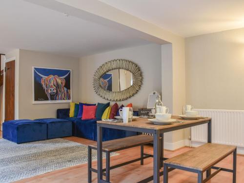a living room with a blue couch and a table at The Barn in Chipperfield