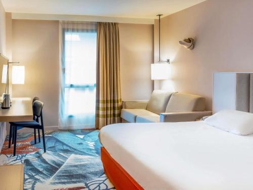a hotel room with a bed and a desk at Mercure Amiens Cathédrale in Amiens
