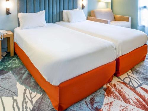 a large bed with an orange frame in a room at Mercure Amiens Cathédrale in Amiens