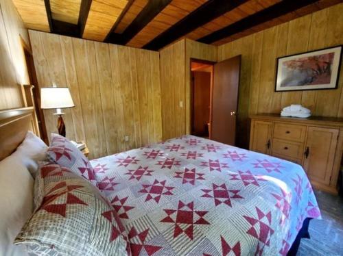a bedroom with a bed with a quilt on it at Gatlinburg Mountain Cabin with Modern Comforts in Chalet Village