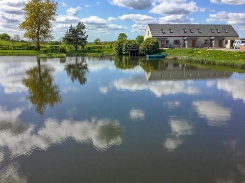 a house on the shore of a lake at Carribber Beech in Torphichen