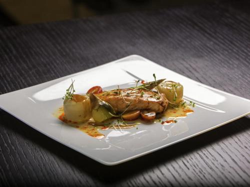 a plate of food with meat and vegetables on a table at Novotel Chennai Sipcot in Chennai