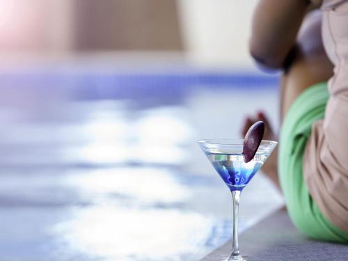 a blue drink with a spoon in a martini glass at Novotel Chennai Sipcot in Chennai