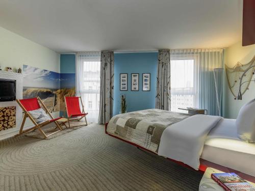 a bedroom with a large bed and two chairs at ibis Styles Hotel Berlin Mitte in Berlin