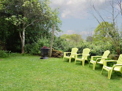 a group of yellow chairs sitting in the grass at Arne Barn in Arne