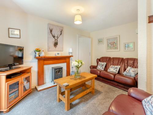 a living room with a couch and a fireplace at Carraig-Dhubh South - Uk47124 in Whiting Bay