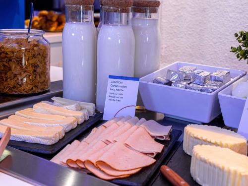 a buffet with cheese and meats and bottles of milk at Ibis budget Wien Messe in Vienna