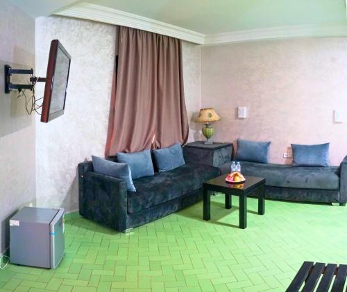 a living room with a couch and a table at Hotel Nouzha in Fès