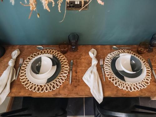 a wooden table with two plates and mirrors on it at The Green One On The End in Thurton