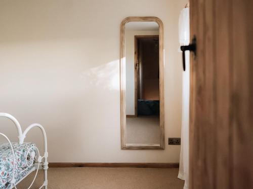 a bedroom with a mirror and a bed in a room at The Green One On The End in Thurton