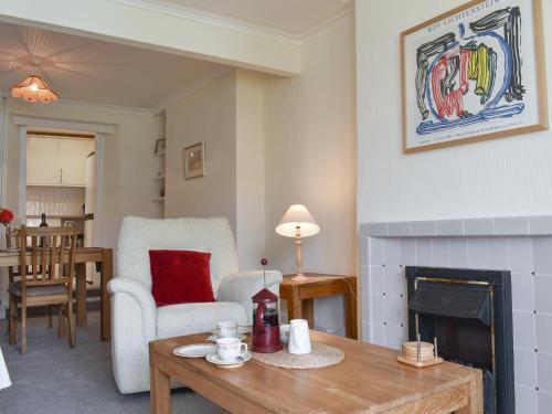 ein Wohnzimmer mit Tisch und Kamin in der Unterkunft Steps End in Brixham