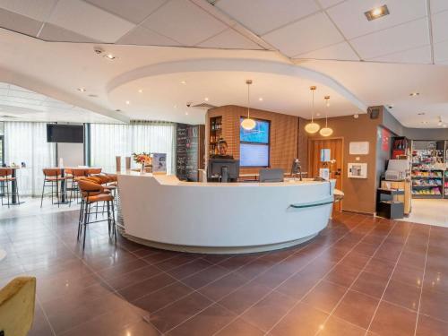 a large lobby with a large island in the middle at Novotel Suites Paris Issy Les Moulineaux in Issy-les-Moulineaux