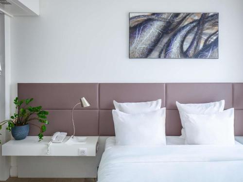 a hotel room with two beds and a table with a phone at Novotel Suites Paris Issy Les Moulineaux in Issy-les-Moulineaux
