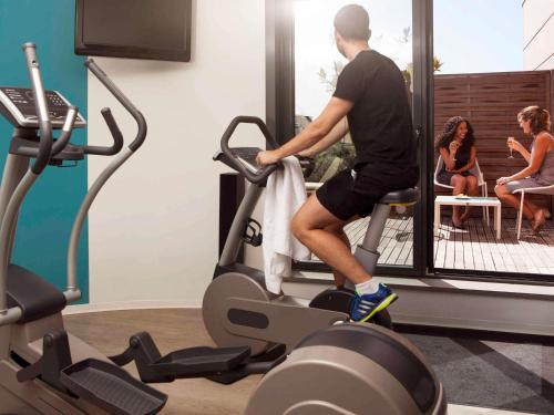 a man riding on a treadmill in a gym at Novotel Suites Paris Issy Les Moulineaux in Issy-les-Moulineaux