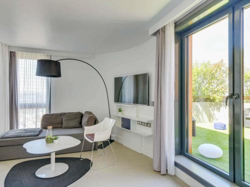 a living room with a couch and a table at Novotel Suites Paris Issy Les Moulineaux in Issy-les-Moulineaux