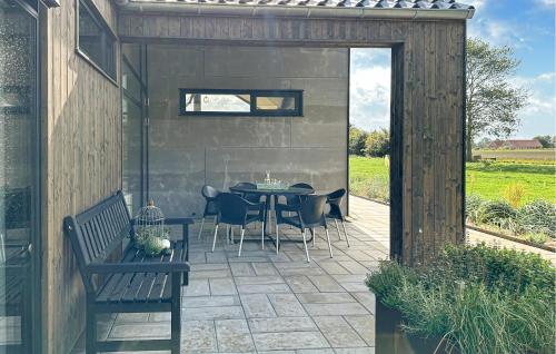 a patio with a table and chairs and a bench at 3 Bedroom Amazing Home In Nexø in Neksø
