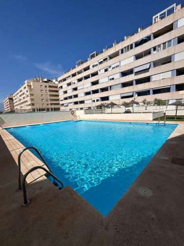 a large swimming pool in front of a building at Apartamentos JM - Sea & Sun in Roquetas de Mar