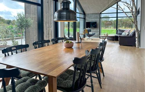 a dining room with a large wooden table and chairs at 3 Bedroom Amazing Home In Nexø in Neksø