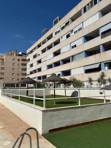 a large building with umbrellas in front of it at Apartamentos JM - Sea & Sun in Roquetas de Mar
