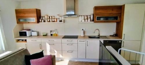 a small kitchen with white cabinets and a sink at Apartmán Slunečná in Moravská Třebová