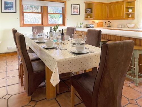 a dining room with a table and chairs and a kitchen at Innish - Uk38783 in Clachan