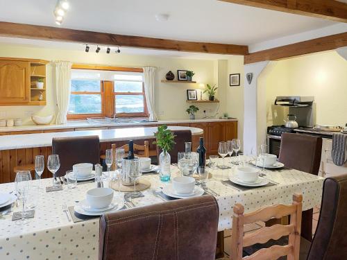 a dining room with a table and chairs and a kitchen at Innish - Uk38783 in Clachan