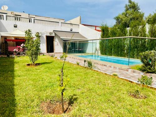 una casa con piscina en un patio en Belle villa spacieuse et calme avec piscine à 7min de la plage en voiture, en Tamaris