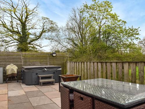 a patio with a grill and a table and a fence at The Barbon - Uk47033 in Kirkby Lonsdale