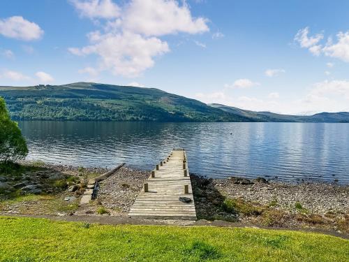 a wooden dock on the shore of a lake at Shoreside in Aberfeldy