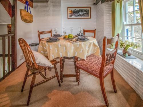 a dining room with a table and chairs and a table and chairsktop at Charlie Wilcox Cottage in Polperro