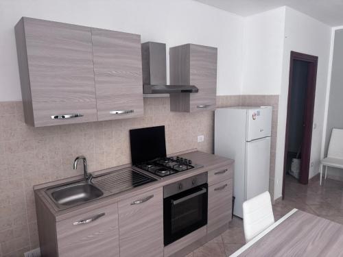 a kitchen with a stove and a sink and a refrigerator at Casa Colle Verde in Conocchia