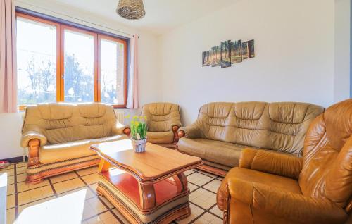 a living room with leather furniture and a table at Havre De Paix À La Campagne in Lebiez