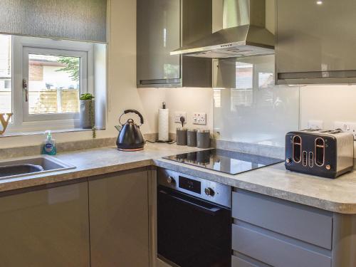 a kitchen with a sink and a toaster on the counter at Park View in Martham