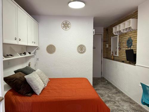 a bedroom with a bed with an orange blanket at Sandra's home in La Pineda