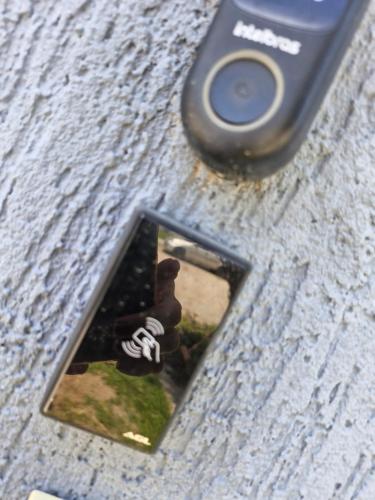a cell phone with a picture of a person on it at Suíte tripla com vista piscina em casa familiar de luxo em Itaipu in Niterói