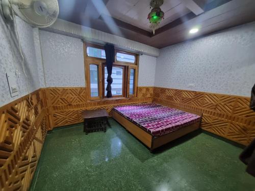 an empty room with a bed and a window at Shanti cafe and stay in Kasol