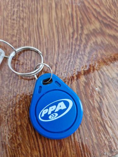 a blue papa key chain on a wooden table at Suíte tripla com vista piscina em casa familiar de luxo em Itaipu in Niterói