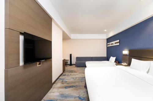 a hotel room with two beds and a flat screen tv at Holiday Inn Express Shenyang North Station by IHG in Shenyang