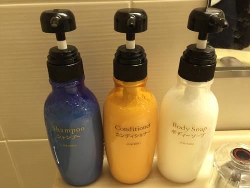 a group of three bottles of detergents on a counter at Hotel Socia in Hita