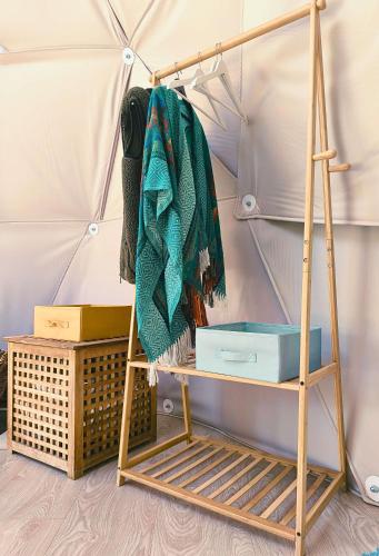 a shelf with a blanket on it next to a tent at Pacha Garden - The Dome in Miceşti