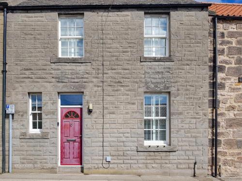 a brick building with a red door and windows at Number Twenty-Nine in Berwick-Upon-Tweed