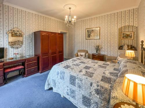 a bedroom with a bed and a dresser and a desk at Tigh N Eilean in Aberfeldy