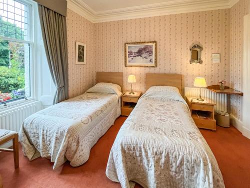 a bedroom with two beds and a window at Tigh N Eilean in Aberfeldy
