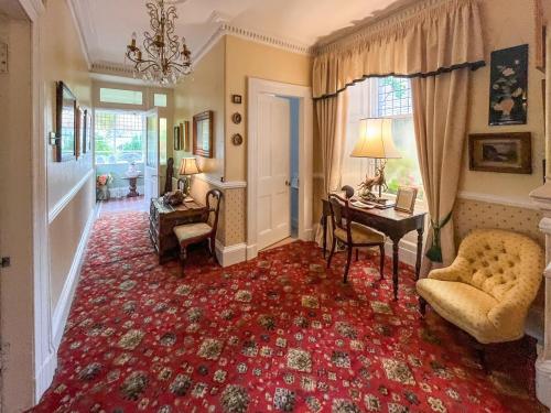 a living room with a chair and a table and a desk at Tigh N Eilean in Aberfeldy
